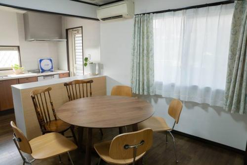 eine Küche mit einem Tisch und Stühlen im Zimmer in der Unterkunft ミセスマルベリー in Utazu