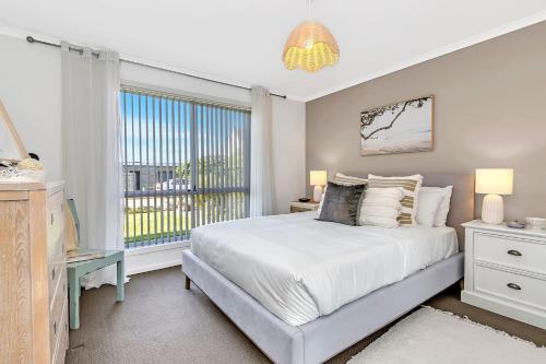 um quarto com uma cama grande e uma janela em Shore Haven - A Relaxed Seaside Stay em Port Noarlunga