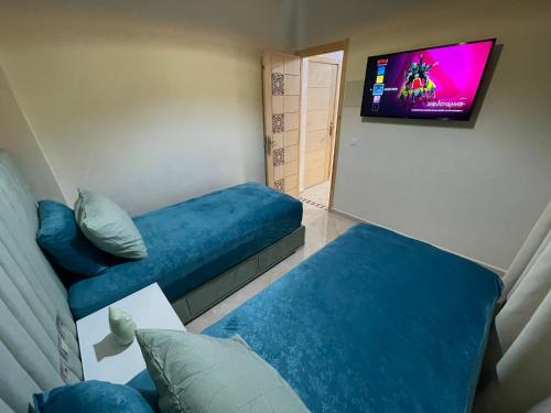 Zimmer mit 2 blauen Betten und einem Flachbild-TV in der Unterkunft Magnifique appartement moderne (avec Wifi) in Fès
