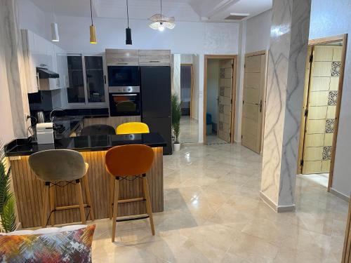 eine Küche mit zwei Barhockern und einer Theke in der Unterkunft Magnifique appartement moderne (avec Wifi) in Fès