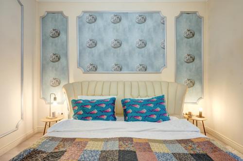 a bedroom with a bed with two blue pillows at Beautiful 2BedFlatCismigiu in Bucharest