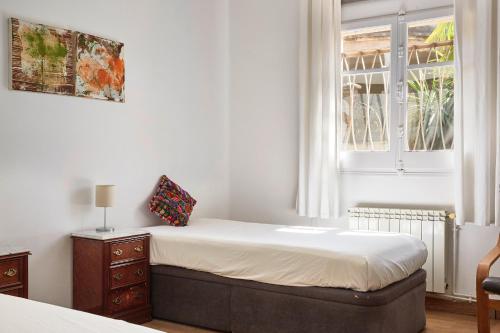 a bedroom with a bed and a window at casabelladona Barcelona in Barcelona