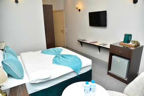 a hotel room with a bed with blue pillows at Karat Inn Boutique Hotel in Baku