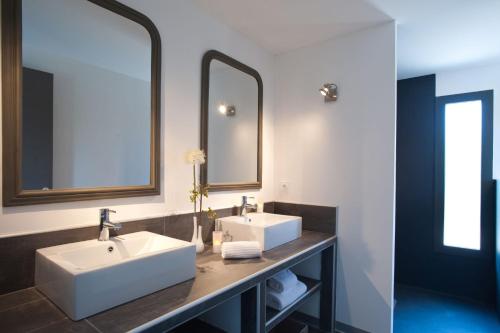 ein Badezimmer mit zwei Waschbecken und zwei Spiegeln in der Unterkunft Casa Julia in Conca