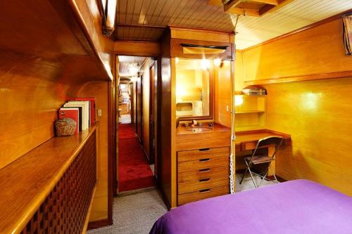 1 dormitorio con cama, lavabo y escritorio en Classic riverboat in the center of Paris, en París