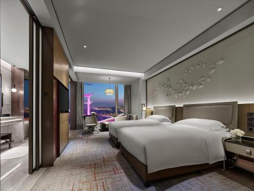 2 łóżka w pokoju hotelowym z widokiem w obiekcie InterContinental Quanzhou, an IHG Hotel w mieście Quanzhou