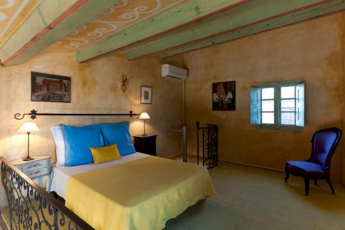 Un dormitorio con una cama y una silla en una habitación. en Le Maria Venezia, en LʼÎle-Rousse