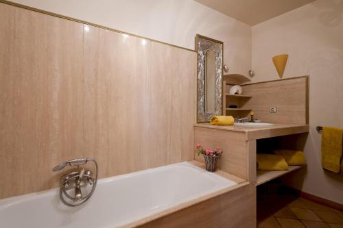 La salle de bains est pourvue d'une baignoire et d'un lavabo. dans l'établissement Le Maria Venezia, à LʼÎle-Rousse