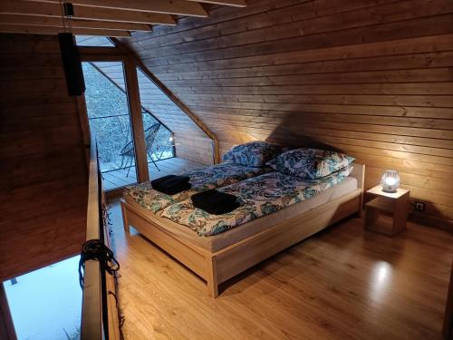 Un dormitorio con una cama en una habitación de madera. en Czarna Chata, en Jaworzynka