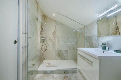 een witte badkamer met douche en wastafel bij Welcome to the Verde in Alfortville