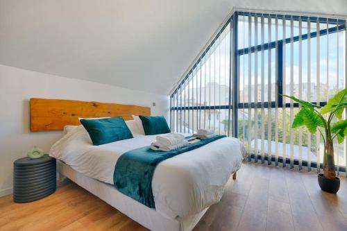 een slaapkamer met een groot bed met een groot raam bij Welcome to the Verde in Alfortville