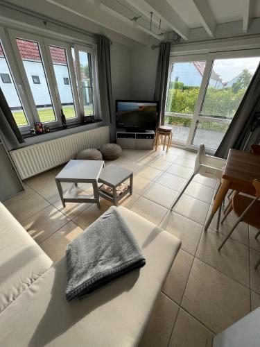 a living room with a couch and a tv at vakantiewoning Heidehoek in Middelkerke