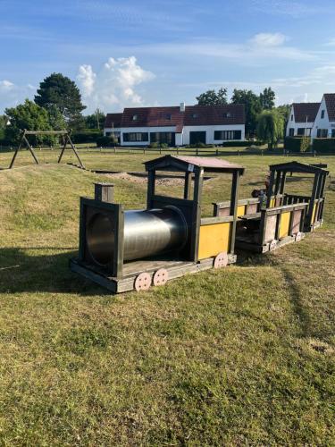 a toy train in a field with a playground at vakantiewoning Heidehoek in Middelkerke