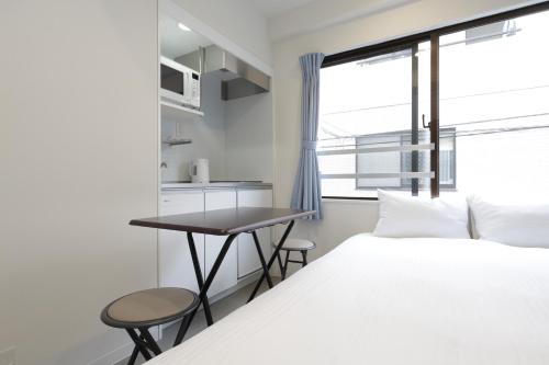 a bedroom with a bed and a desk and a window at IKEBUKURO MANGA HOUSE in Tokyo