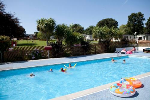 um grupo de pessoas a nadar numa piscina em Camping Pods Trevella Holiday Park em Crantock