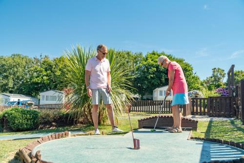 an older man and woman playing a game of golf at Camping Pods Trevella Holiday Park in Crantock
