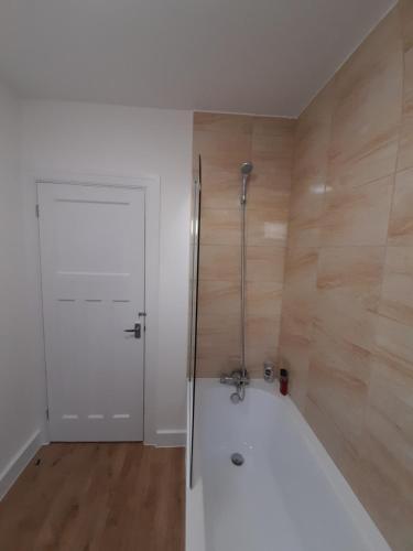 baño con ducha y puerta blanca en Matipa-Rise Guest House Southampton, en Southampton