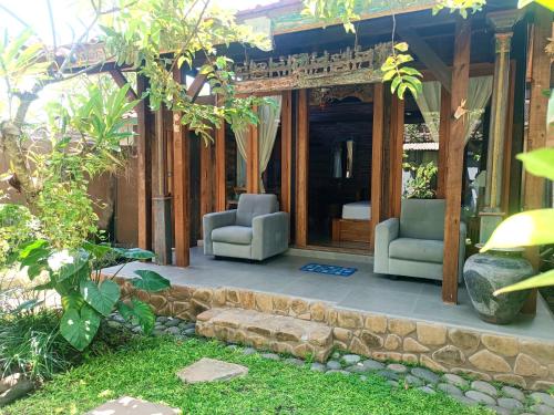 a patio with two chairs and a house at Katang - Katang Guest House in Denpasar