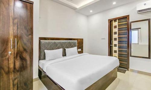 德拉敦的住宿－FabExpress Mohan Vilas Residency，卧室配有一张白色大床