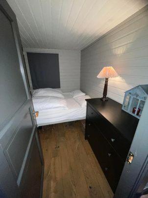 een kleine slaapkamer met een bed en een lamp op een dressoir bij Hovden in Hovden
