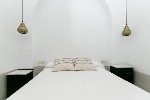 CORRALA LA ALMOHADA في غرناطة: غرفة نوم بسرير ابيض مع مواقف ليلتين