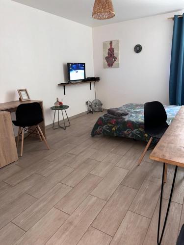 een kamer met een bed en stoelen en een bureau bij Studio cosy - Sainte-Clotilde in Saint-Denis