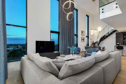 a living room with a large couch and a tv at PH106 The best views in Tallinn! in Tallinn