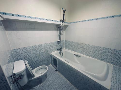 La salle de bains est pourvue de toilettes, d'une baignoire et d'un lavabo. dans l'établissement นวนคร ออมสินอพาร์ตเมนต์ ติดห้างบิกซี Navanakorn Aomsin hotel near shopping mall,snooker and club, à Ban Lam Rua Taek