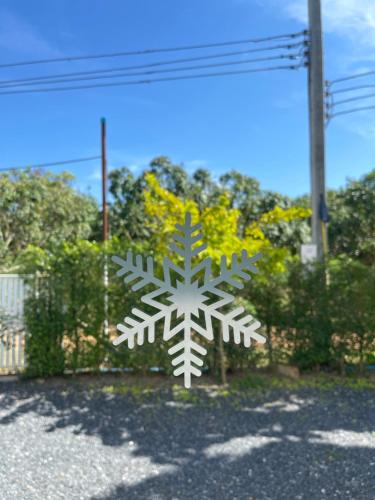 a white snowflake is hanging on a fence at Maryland Khaoyai Annapolis Pool Villa in Ban Nong Song Hong
