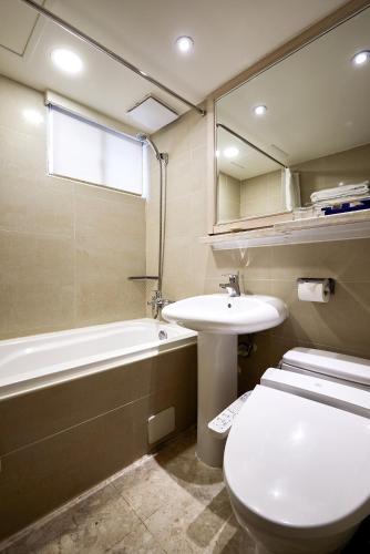 a bathroom with a toilet and a sink and a bath tub at K Hotel Taipei in Taipei
