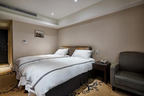a hotel room with a bed and a chair at K Hotel Taipei in Taipei