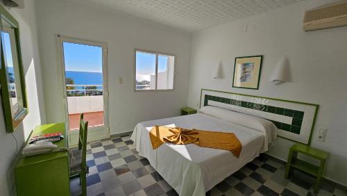 a bedroom with a large bed and a balcony at Hotel El Puntazo I in Mojácar