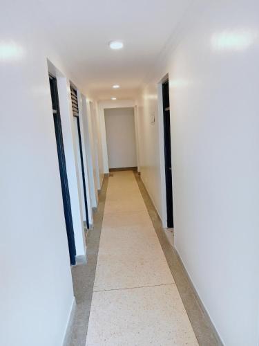 a hallway in a building with white walls and a tile floor at MELVIC INN in Kisumu