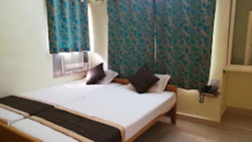 a bedroom with a bed in a room with a window at Hotel Akashdeep, Ranchi in Rānchī