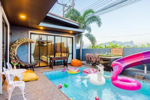 a pool with a slide in a house at The blue mountain pool villa cha-am in Ban Hup Kaphong