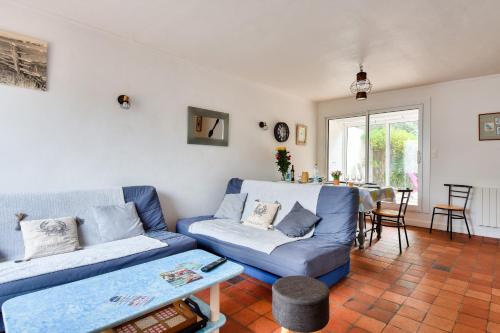 un salon avec un canapé bleu et une table dans l'établissement Instants de détente et de partage aux sables d'or, à La Guérinière