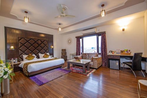 a bedroom with a large bed and a desk and a desk at Hotel Solar Residency in Srinagar