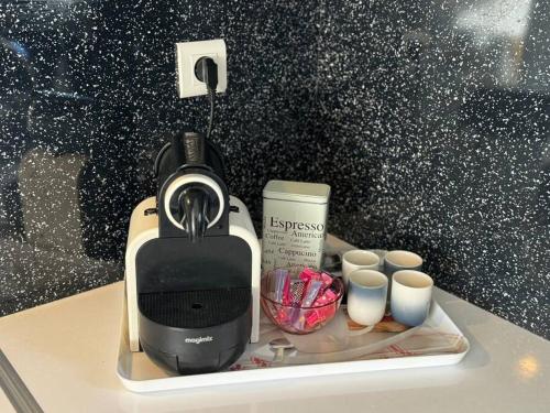 a coffee maker and some cups on a counter at Cozy apartment with balcony 1 minute from the sea / Appartement T2 cosy avec balcon à 1 min de l'océan in Capbreton