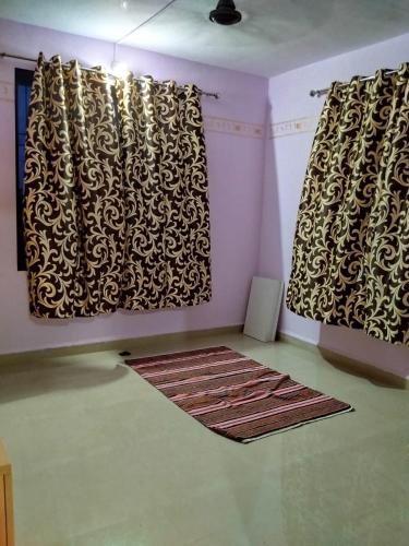 a room with black and white curtains and a rug at Darsh Bungalow....Amol Pade in Neral