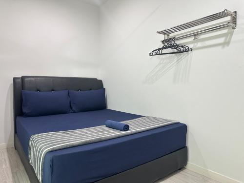 a bed with a blue headboard and a shelf at SA Sutera Avenue Homestay Kota Kinabalu Area KK City Opposite Imago in Kota Kinabalu