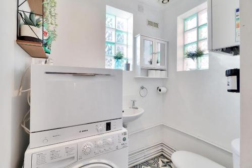 a white bathroom with a washer and dryer at Pass the Keys Cute flat in Tonbridge in Tonbridge