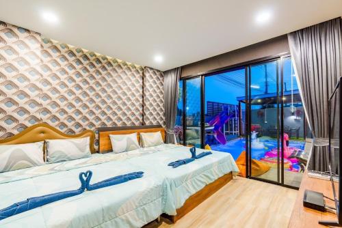 a bedroom with a large bed and a large window at The blue mountain pool villa cha-am in Ban Hup Kaphong