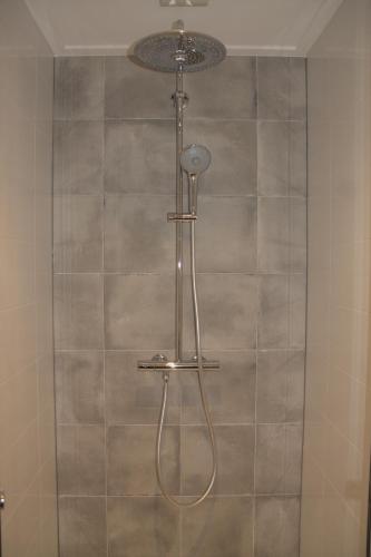 a shower with a shower head in a bathroom at Het Lokaal in Cornjum
