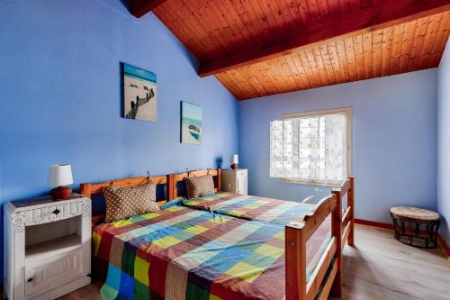 - une chambre avec un lit et une couverture colorée dans l'établissement Bretignolles-sur-mer - 450m de la plage, à Bretignolles-sur-Mer
