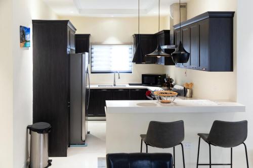 a kitchen with black cabinets and a white counter top at Ms. T's Paradise @ Pyramid Point in Ocho Rios