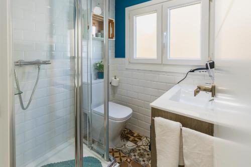 a bathroom with a toilet and a glass shower at Casa El Palo in Málaga