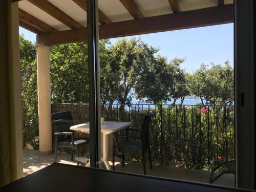 a table and chairs on a balcony with a view of the ocean at Résidence île de beauté in Propriano