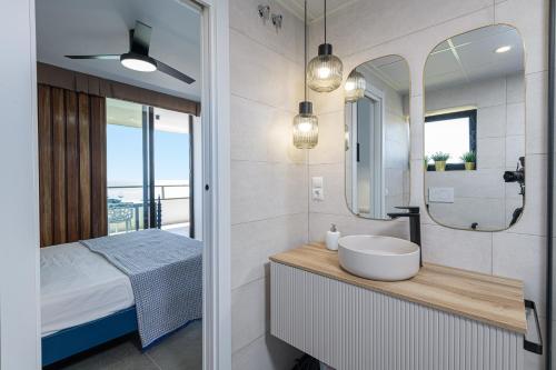 een badkamer met een wastafel, een bed en een spiegel bij Playamar in Torremolinos