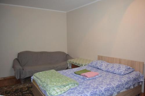 Cette petite chambre comprend un lit et un canapé. dans l'établissement Apartment on 5 microdistrict, 8, à Bishkek