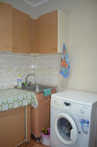 cocina con lavadora y fregadero en Apartment on 5 microdistrict, 8, en Bishkek